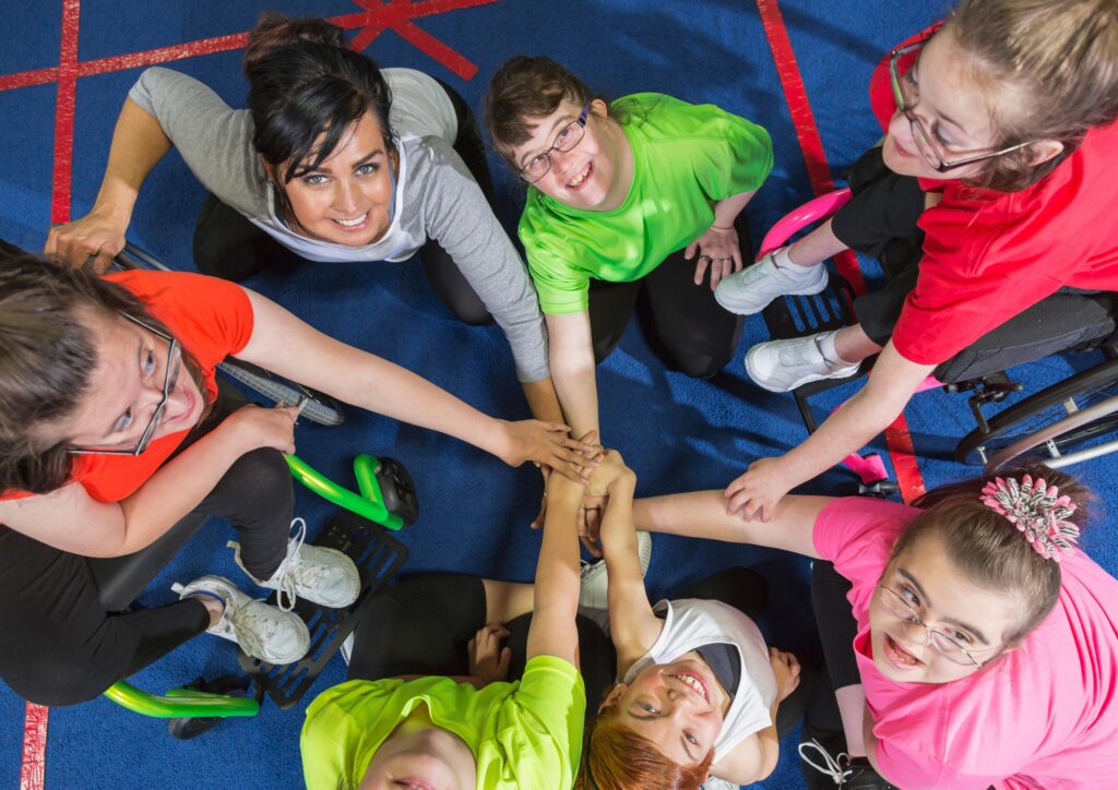 This image includes an adult and several children with special needs. It represents the education of children with special needs.