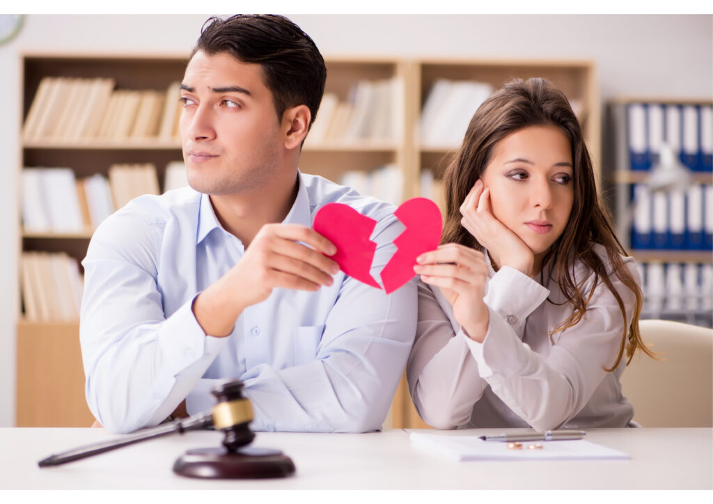 The photo shows two divorcing couples tearing a heart-shaped piece of paper in half. 