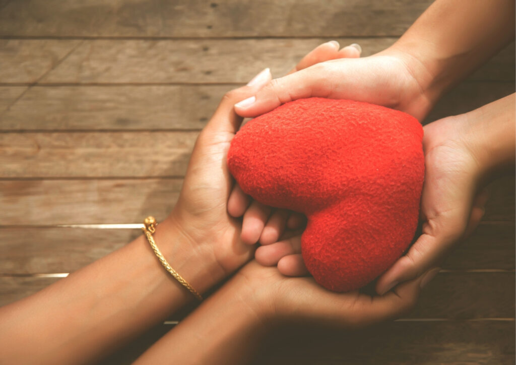 The photo includes a heart held by two people.