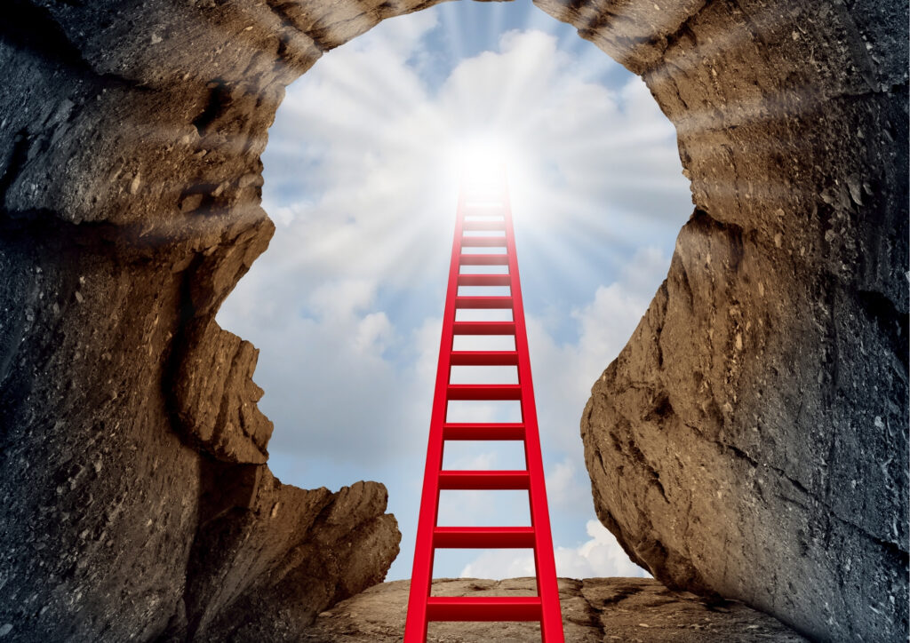 The photo shows the sky through a hole like a human silhouette shaped in a cave . A large red ladder is leaning against the exit point. 