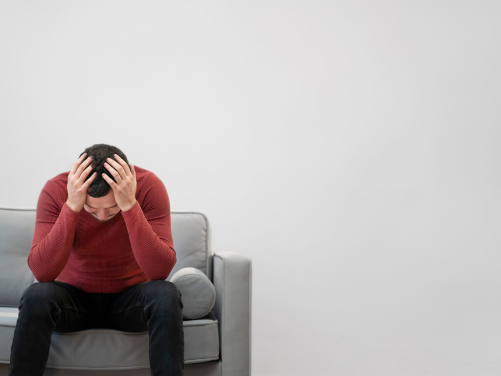 this photo is used to represent ghosting in relationships. the photo shows a sad man hanging his head.