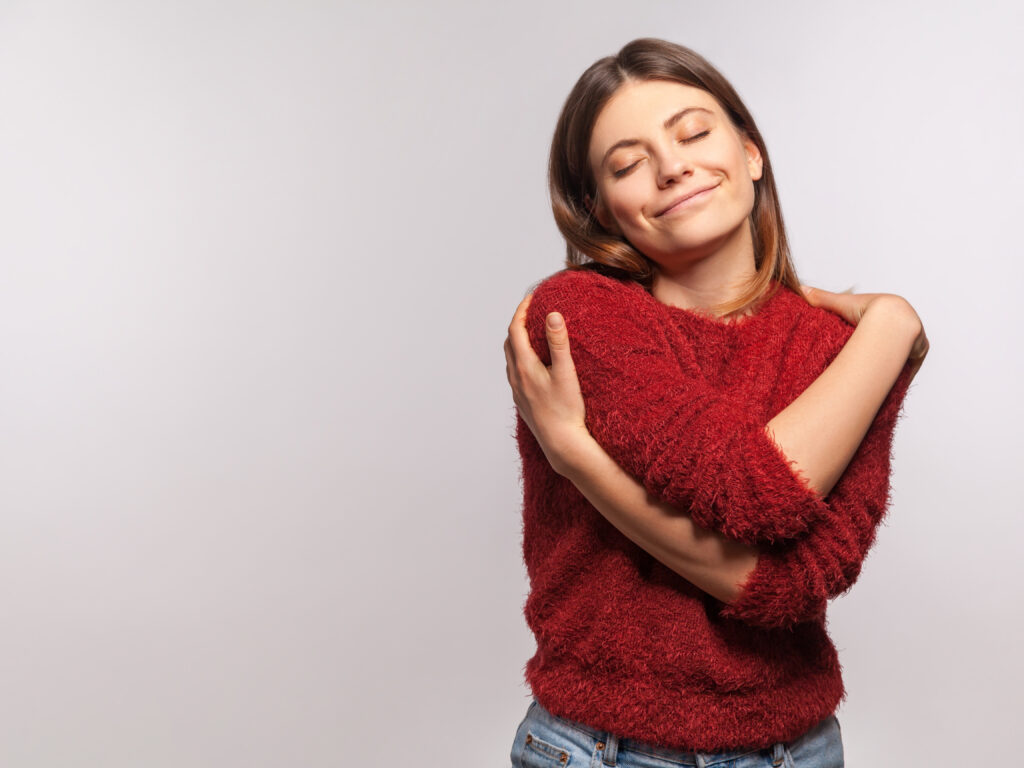 This photo is used to represent self-respect. The photo shows a woman hugging herself.